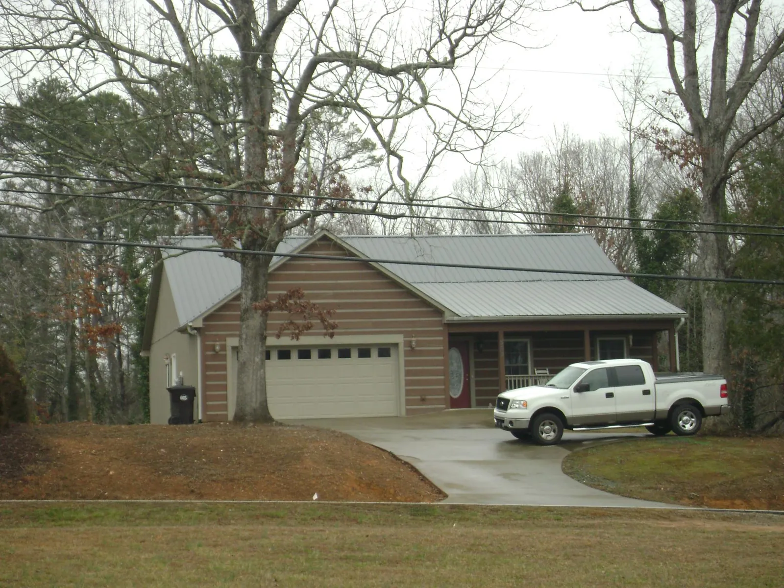 Gray metal roof on a log sided house with an attached two car garage in Hyde Park